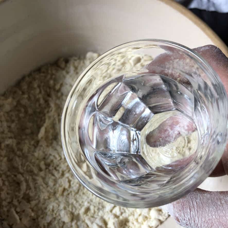 pouring water into the flour-egg mixture