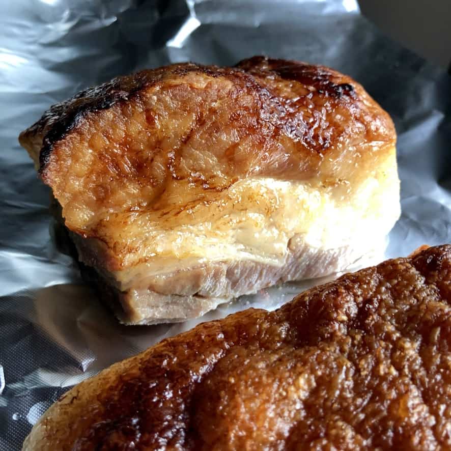 golden brown braised pork belly on aluminum foil after being taken out of the braising liquid to cool