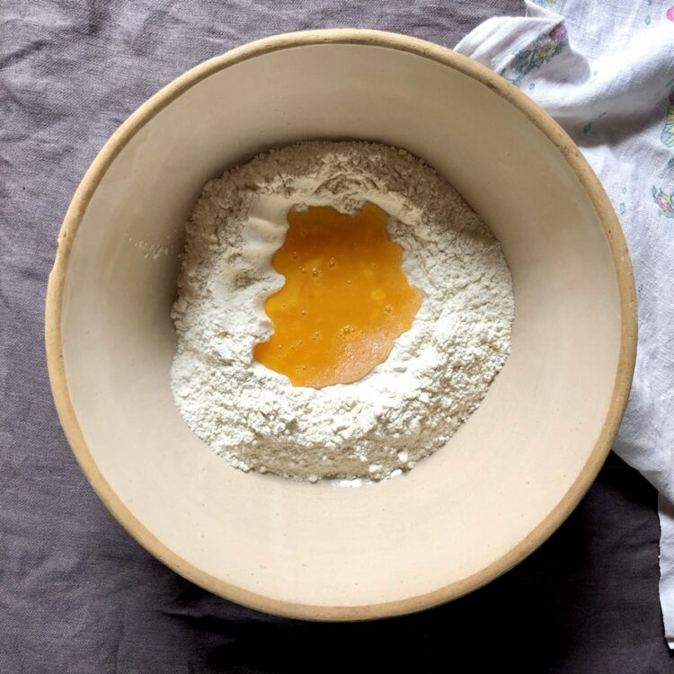 eggs poured into the well of the flour