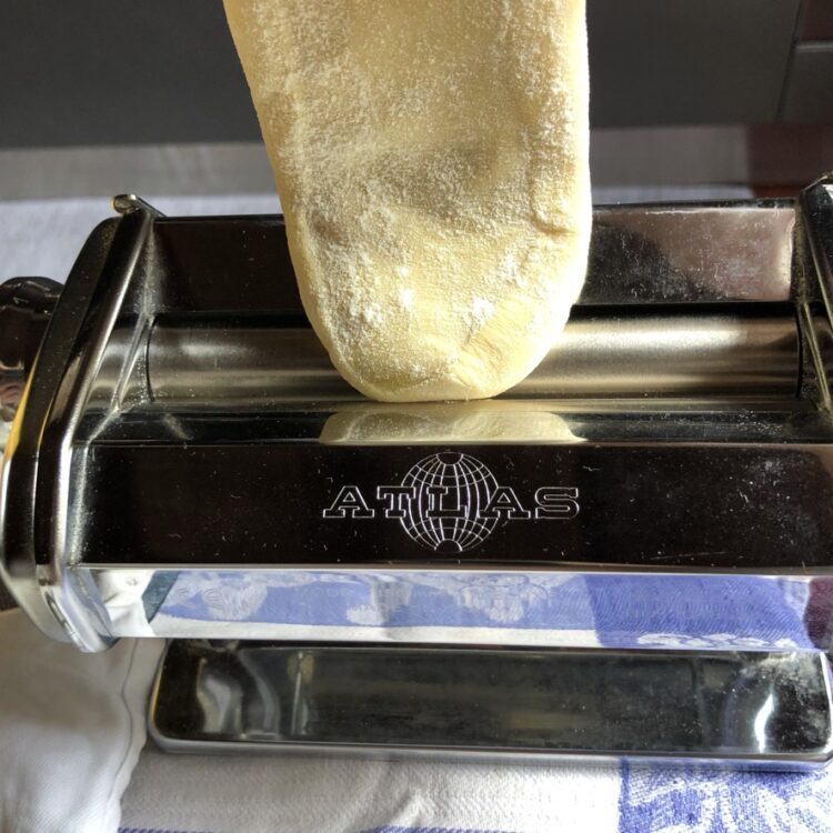 rolling dough on the widest setting of 1 on a pasta machine