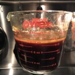 chashu braising liquid in a glass pyrex measuring cup after being strained