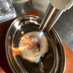 using a an Iwatani kitchen torch to sear the sliced chashu