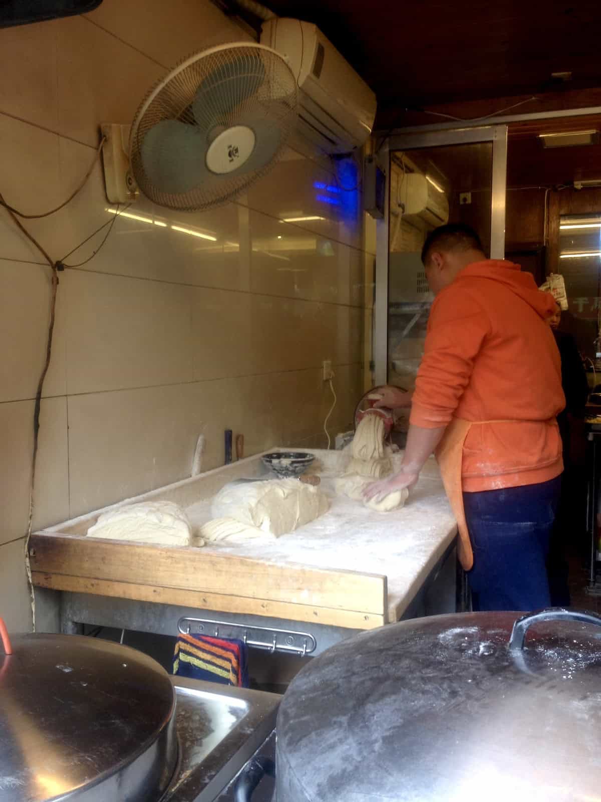 The noodle shop in my old neighborhood in Chengdu, China with an open street view where you can watch the alkaline noodle vendor make homemade alkaline wheat noodles all day long and buy them to take home.
