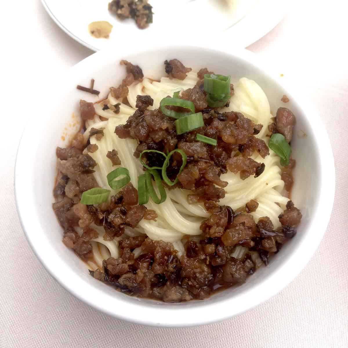 Authentic Sichuan dan dan mian from restaurant in Kuanzhai Alley Wide and Narrow Alley Chengdu showing traditional dan dan noodles recipe authentic Chinese noodles how to make dan dan mian restaurant style Sichuan street food alkaline noodles traditional preparation.