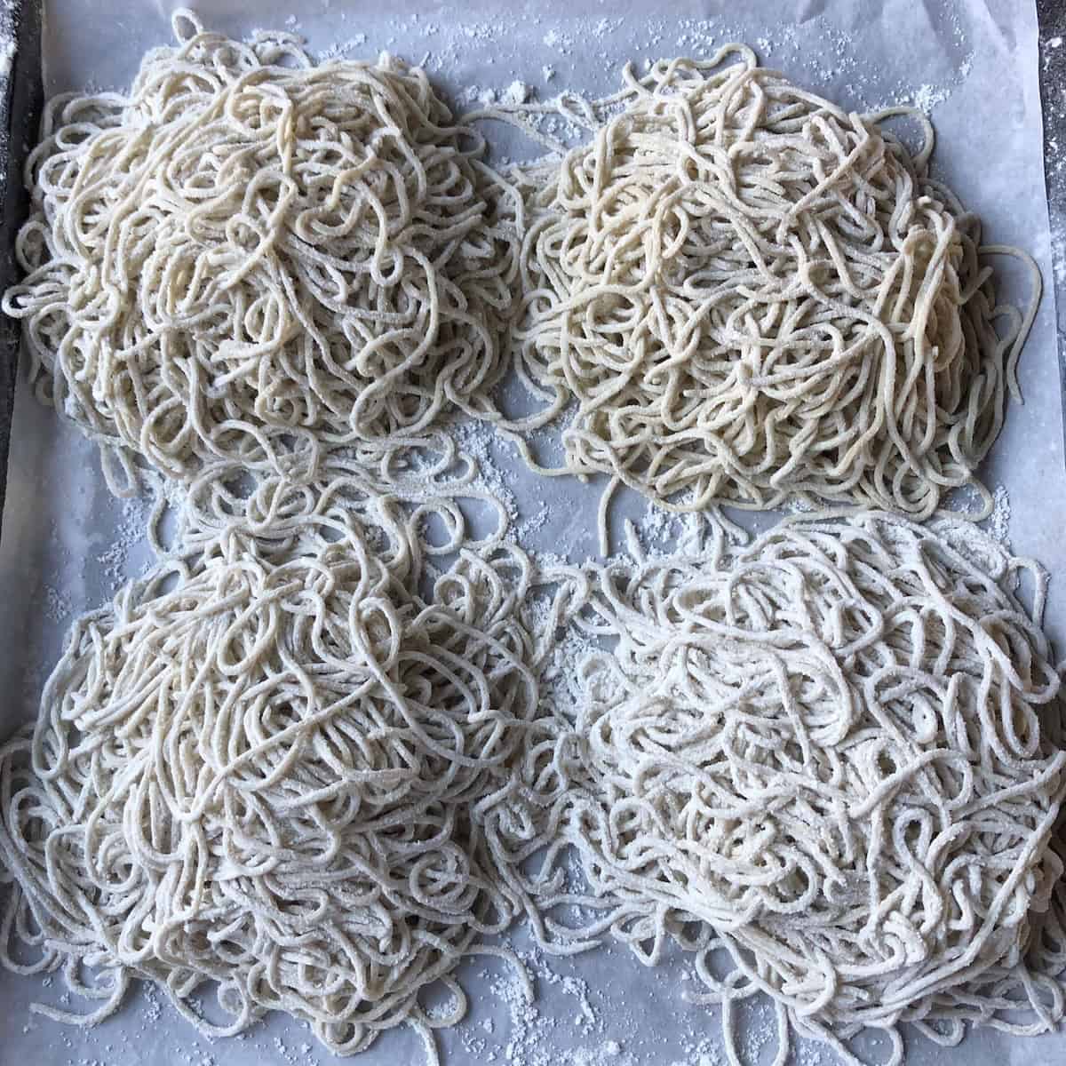 Four nests of dusted ramen noodles hand crinkled to make wavy ramen with cornstarch coating homemade ramen noodles recipe alkaline noodles finished texture how to make ramen curly wavy noodles traditional Japanese style crinkled by hand.
