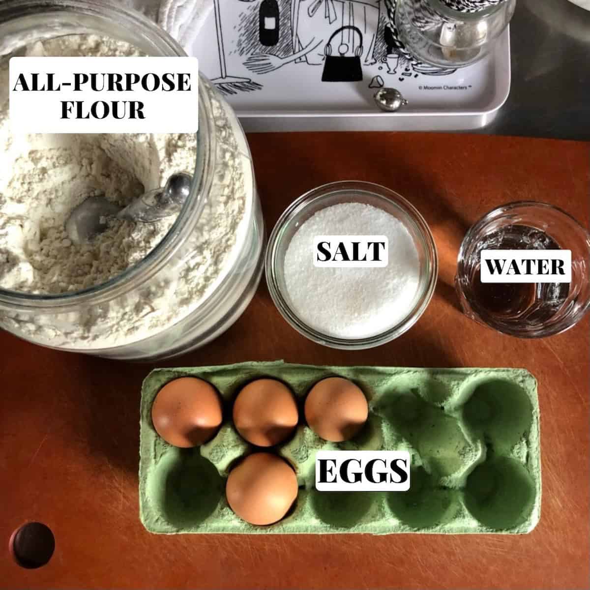 Homemade egg noodle ingredients labeled on cutting board, egg noodles recipe ingredients.
