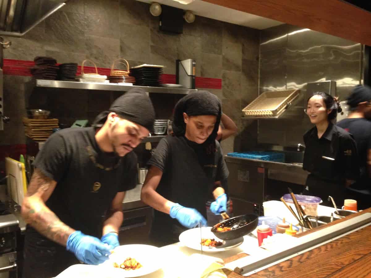 Ippudo restaurant rame chefs cooking and making fresh ramen noodles and appetizers in kitchen showing professional ramen preparation (NYC Japanese restaurant kitchen).