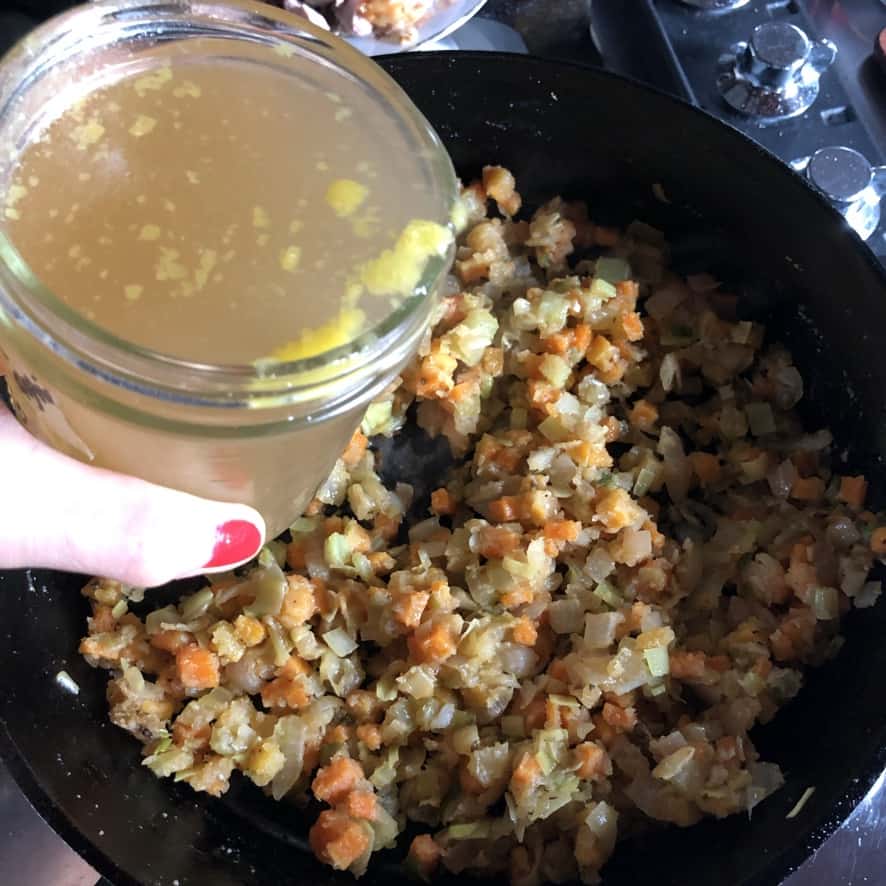 adding chicken stock to the vegetables