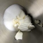 cream cheese and sugar added to the bowl of a stand mixer