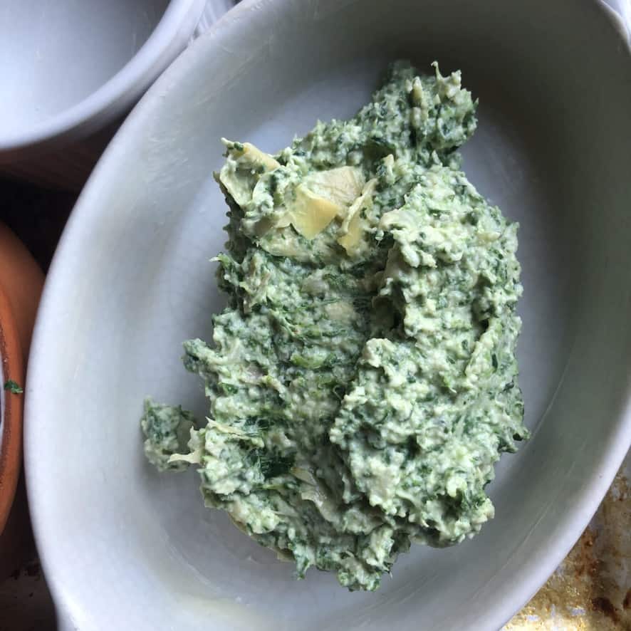 a large spoonful of dip in a buttered ramekin