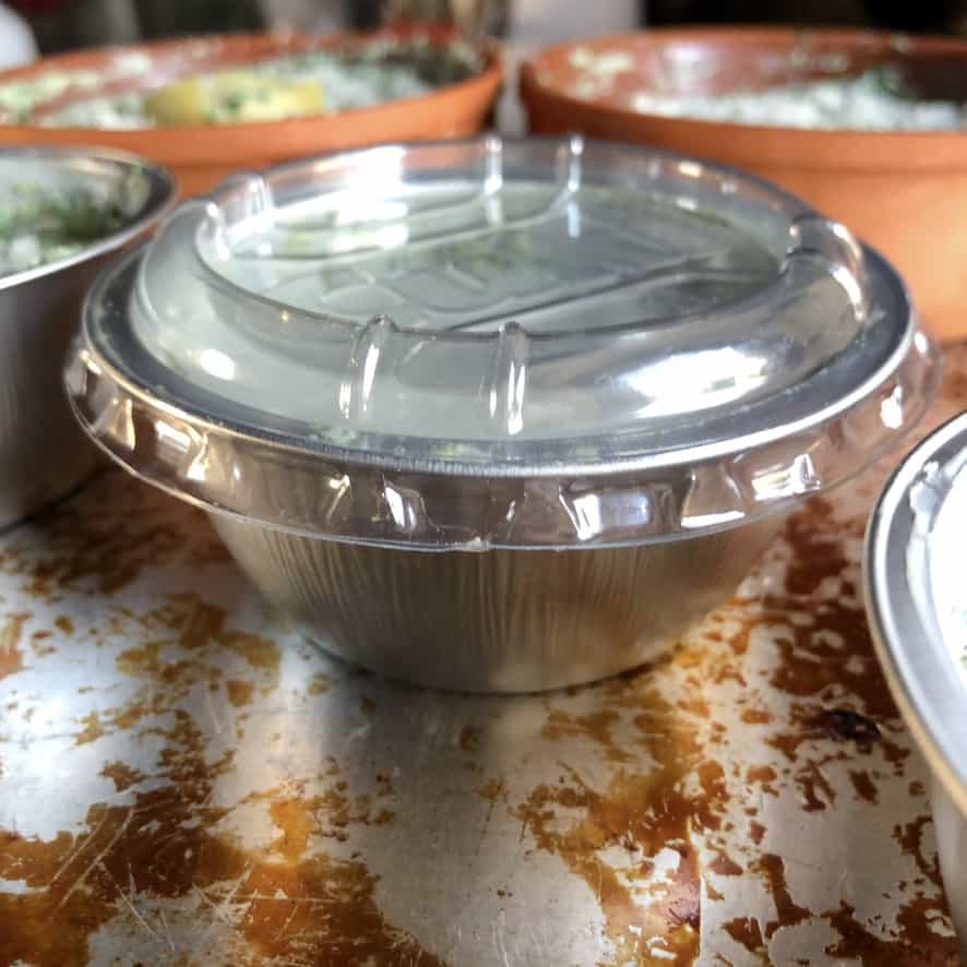 single aluminum foil cup filled with dip and covered with a plastic lid