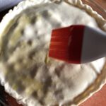 brushing the top pie crust with and egg wash