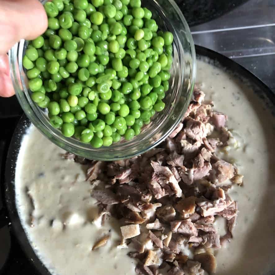 adding turkey and frozen peas to the cream mixture