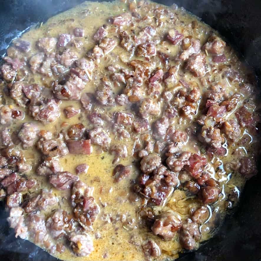 Italian pork sausage, cubed ventricina salami, tiny diced carrots, onoions, garlic, dried sage leaves sautéing in a cast iron skillet after being deglazed with red wine and a little heavy cream added turning the sauce a beautiful almost turmeric color.
