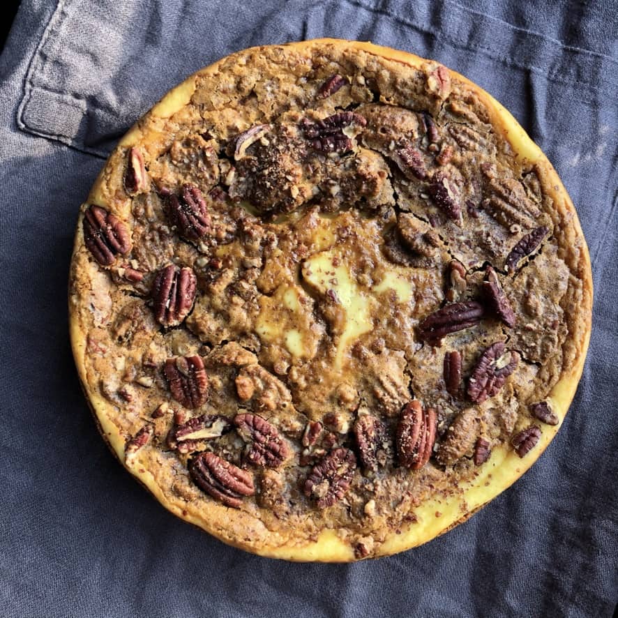 Closeup of a whole Pecan tassie cheesecake with Biscoff cookie crust after cooling (with large pecans and crackly brown sugar tassie filling baked right on to)p.