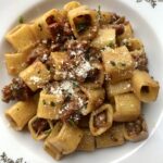 square pasta with sausage and with chopped chives sprinkled on top and grated Grana Padano cheese