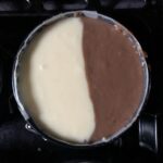 black and white cheesecake batter evenly added to a single mini cheesecake pan before being baked