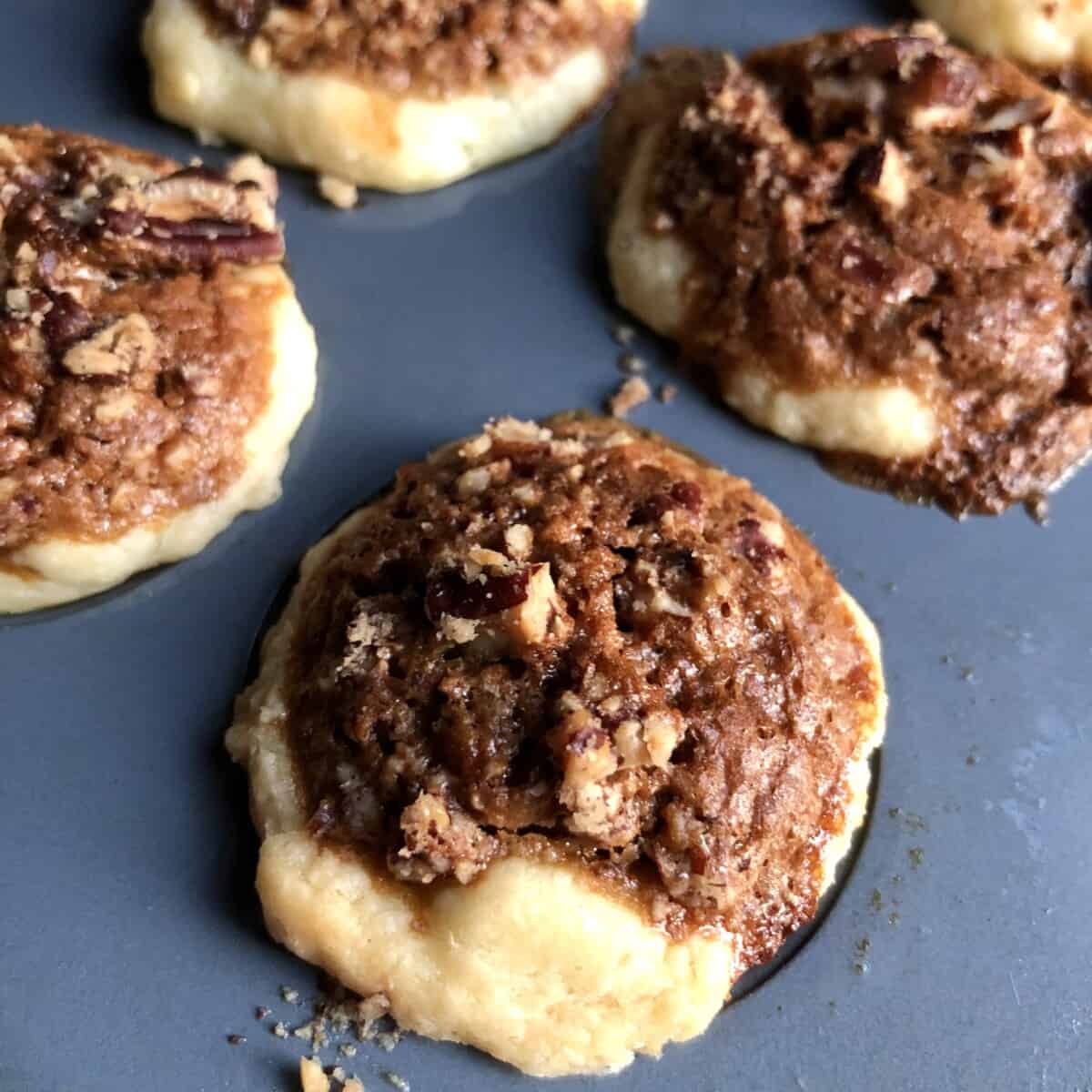 closeup of just baked perfectly golden brown pecan tassies