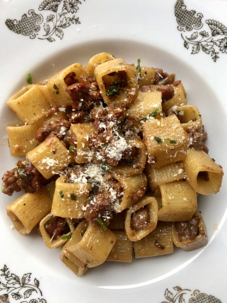 square pasta with sausage and with chopped chives sprinkled on top and grated Grana Padano cheese
