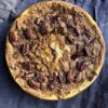 closeup Pecan tassie cheesecake after cooling (with large pecans and crackly brown sugar tassie filling baked right on top.