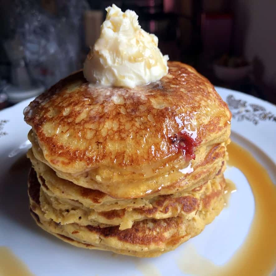 a stack of super soft fully pumpkin berry pancakes with with a large knob of butter melting