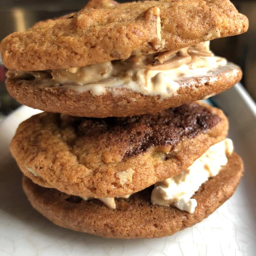 two chocolate chip pecan ice cream cookie sandwiches stacked on top of one another