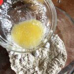 adding melted butter to flour mixture