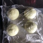 4 bao bun dough balls covered with cling film