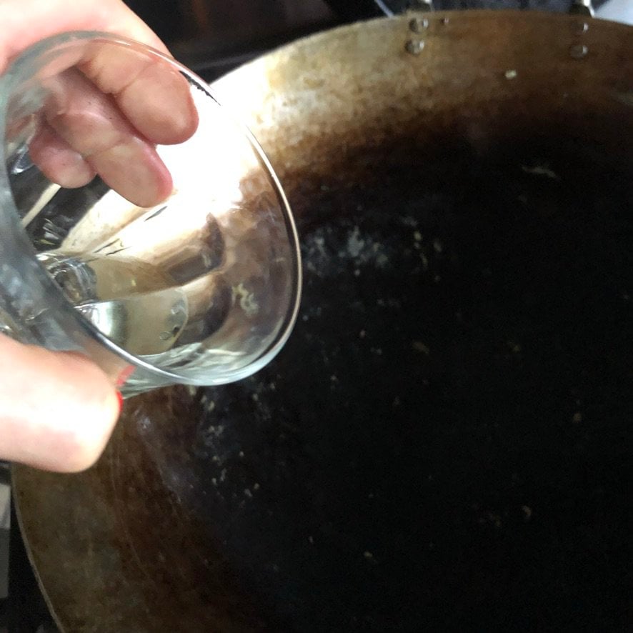 adding a little oil to the wok