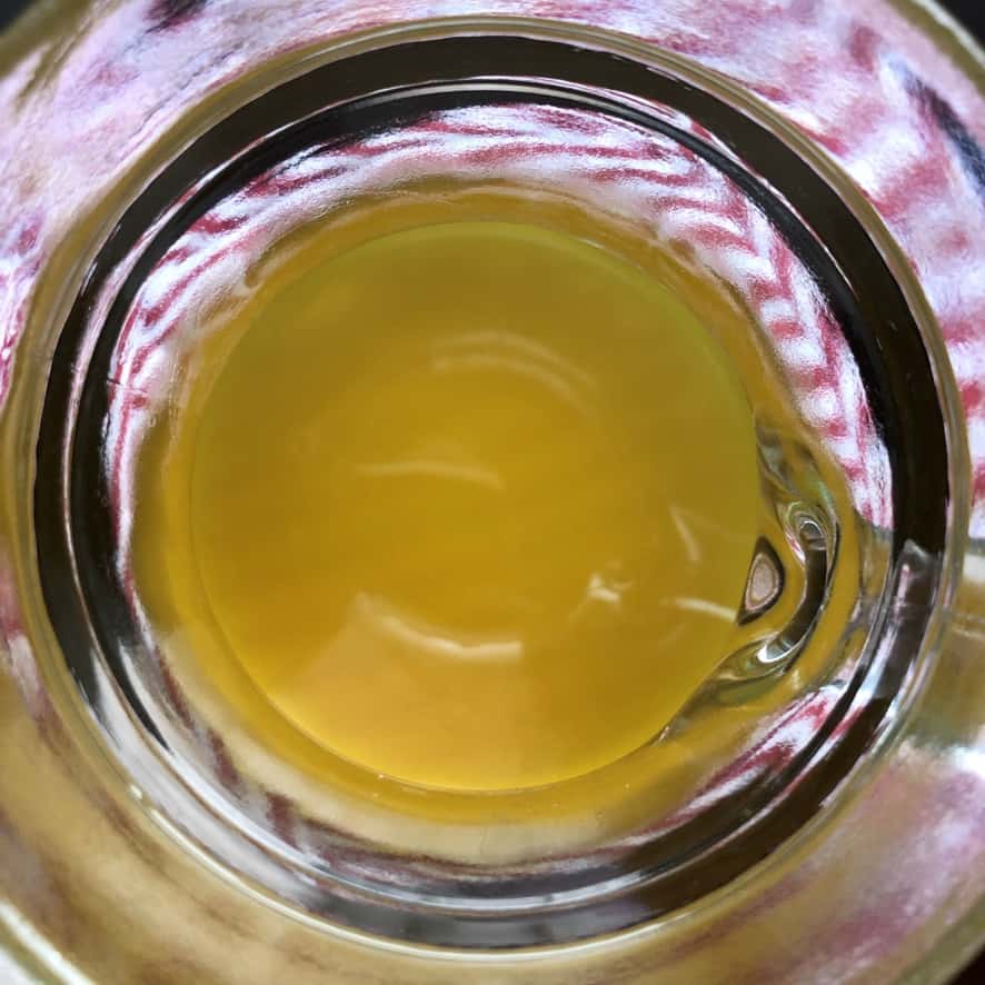 top down view of the cured alcohol with the lemon peels and zest removed (it's very clear and looks like clarified butter)