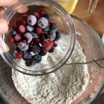 adding berries to whisked flour mixture