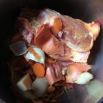 raw chicken, onion and carrot peels and skins, and celery in a pressure cooker pot