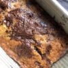 Golden brown dark chocolate covered banana bread after just baking in a loaf pan
