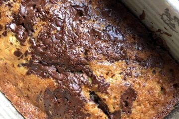 Golden brown dark chocolate covered banana bread after just baking in a loaf pan