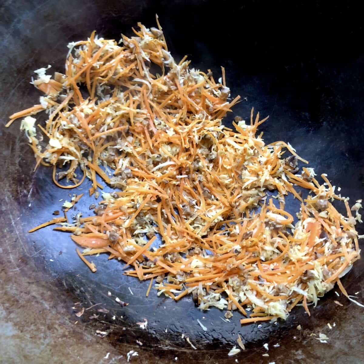 shredded cabbage, carrots, and sliced shitake mushrooms ready for the addition of shaoxing wine to deglaze the wok