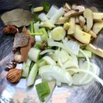 sliced aromatics in a bowl including scallions, ginger, and whole Chinese 5-spice seasoning