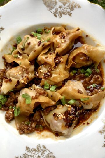 Sichuan wontons with crispy pork and scallions in a bowl
