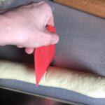 marking the dough "log" with a dough scraper to make even cuts