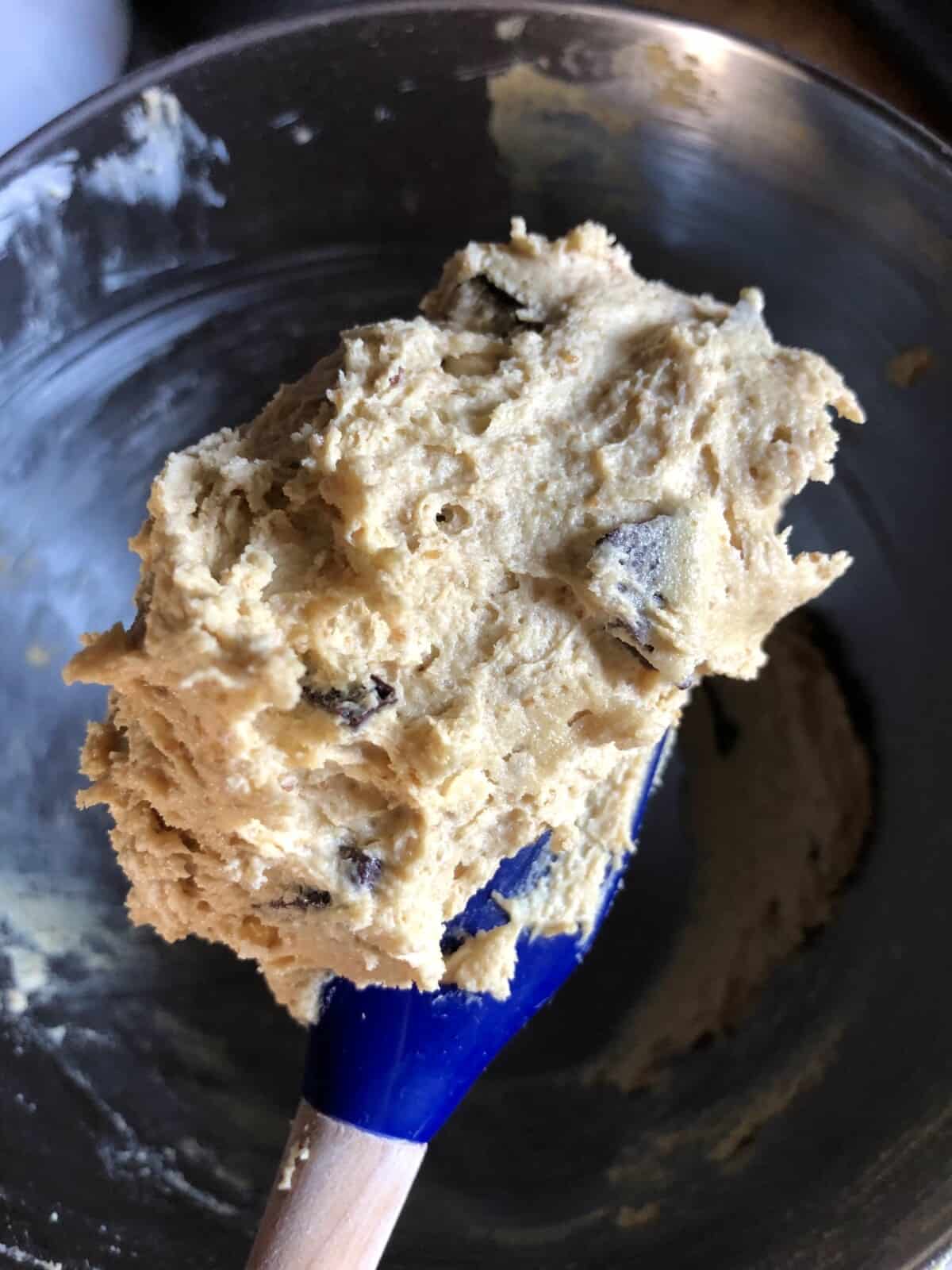 chocolate chip pecan cookie dough on the end of a le creuset blue silicone spatula