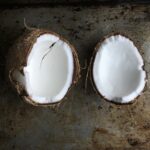 a coconut cut in half to reveal it's milky white flesh