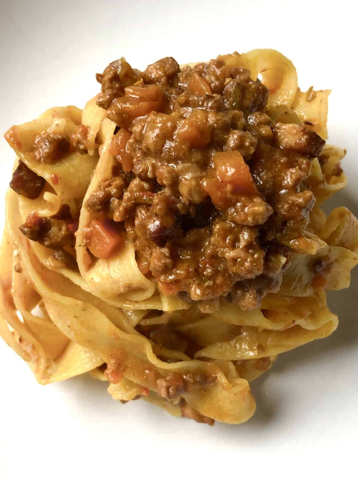 A pasta bowl with a serving of Pappardelle alla Bolognese