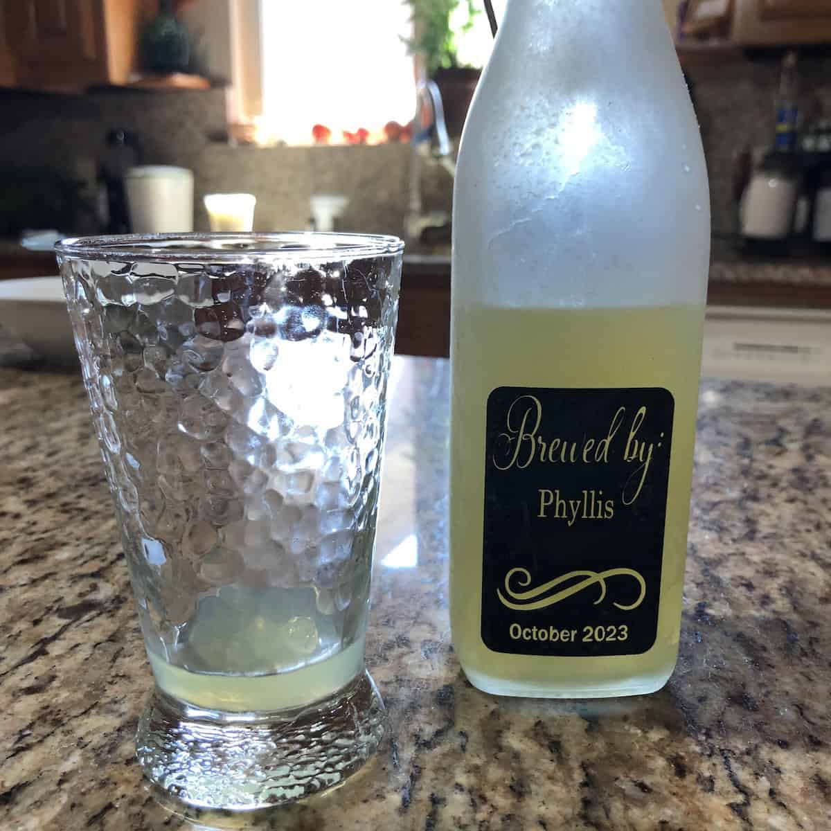 Back label of a homemade Biting at the Bits limoncello recipe in a swing-top bottle reading "brewed by Phyllis 2023", how to make limoncello at home with a custom printed label on an Italian limoncello recipe.