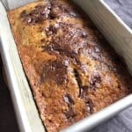 A perfectly baked banana chocolate chip bread with pools of melted chocolate across the top, moist chocolate chip banana bread from scratch.