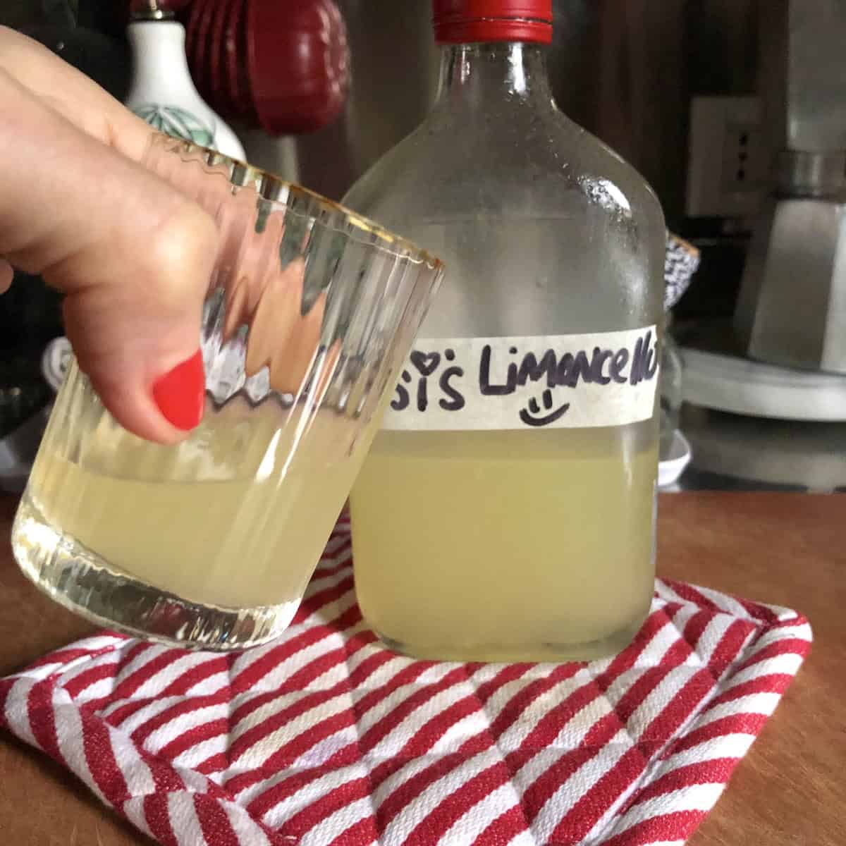 Rosi's homemade limoncello poured into a liqueur glass, limoncello liqueur made from scratch with an authentic Italian limoncello recipe.