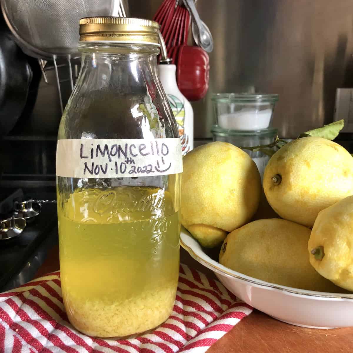 A closed bottle of lemon zest and peels with pure grain alcohol ready to cure, limoncello proof starts high before adding the simple syrup to finish this Italian limoncello recipe.
