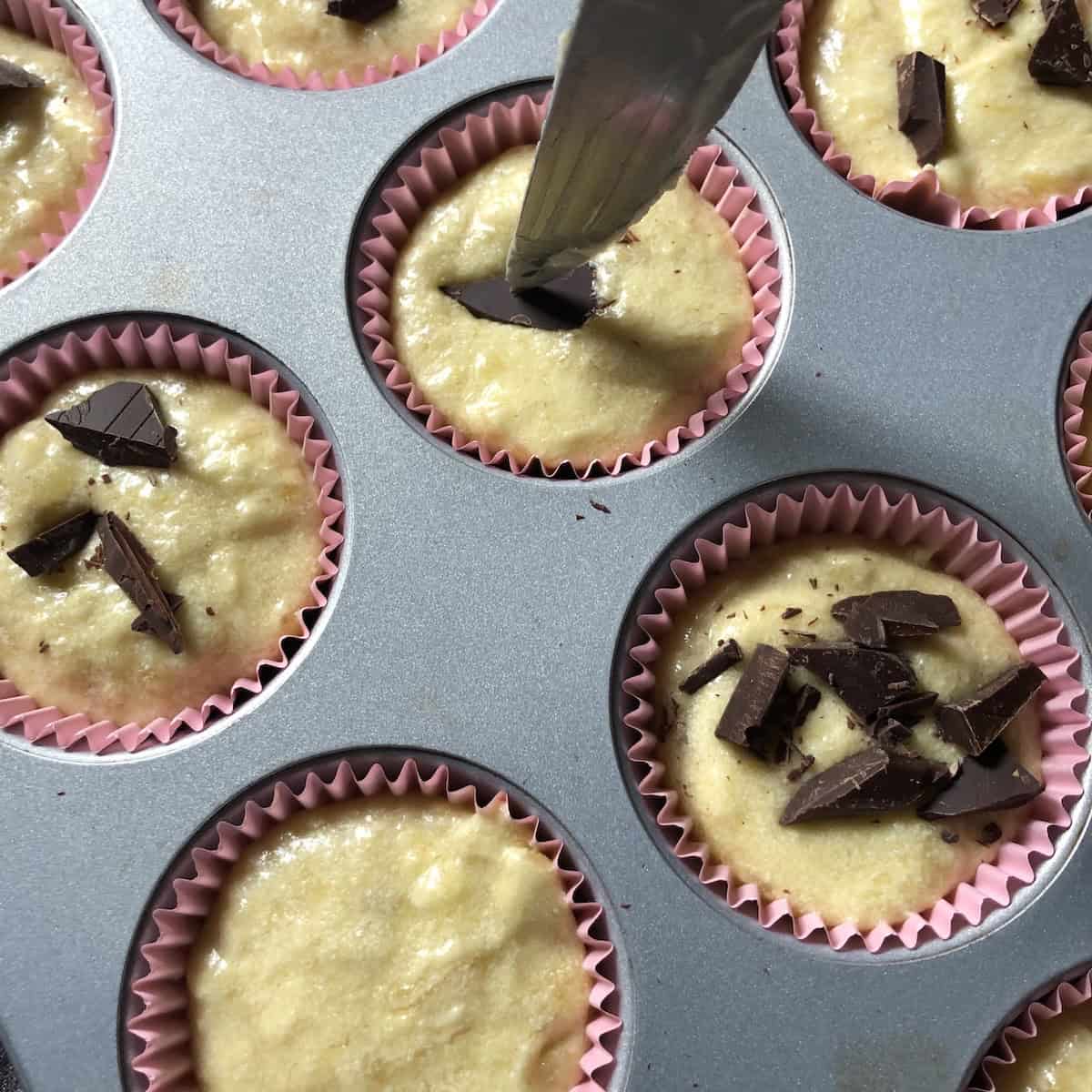 Using a knife to push chocolate chips into the banana bread batter before baking, moist chocolate chip banana bread recipe tip.