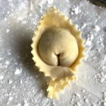 homemade egg wonton wrapper with zigzagged edges filled with a Sichuan ginger-pork filling