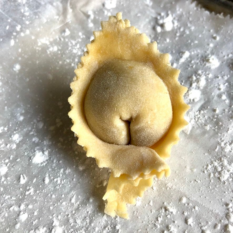 homemade egg wonton wrapper with zigzagged edges filled with a Sichuan ginger-pork filling