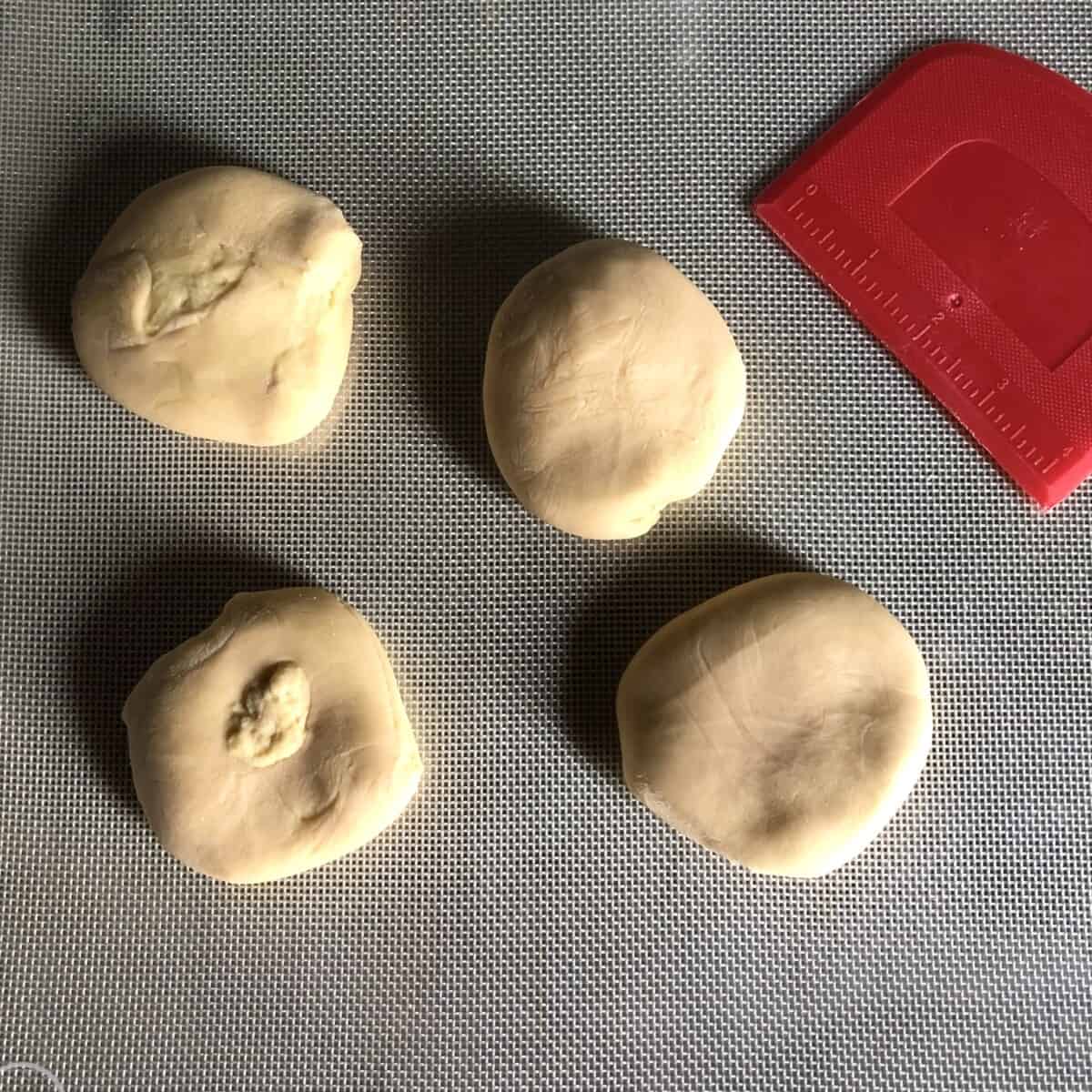 4 dough wonton dough rounds ready to be rolled and rested