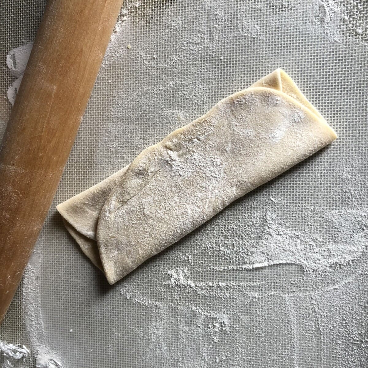 one dough round rolled out and then folded up like a letter to rest for 30 minutes